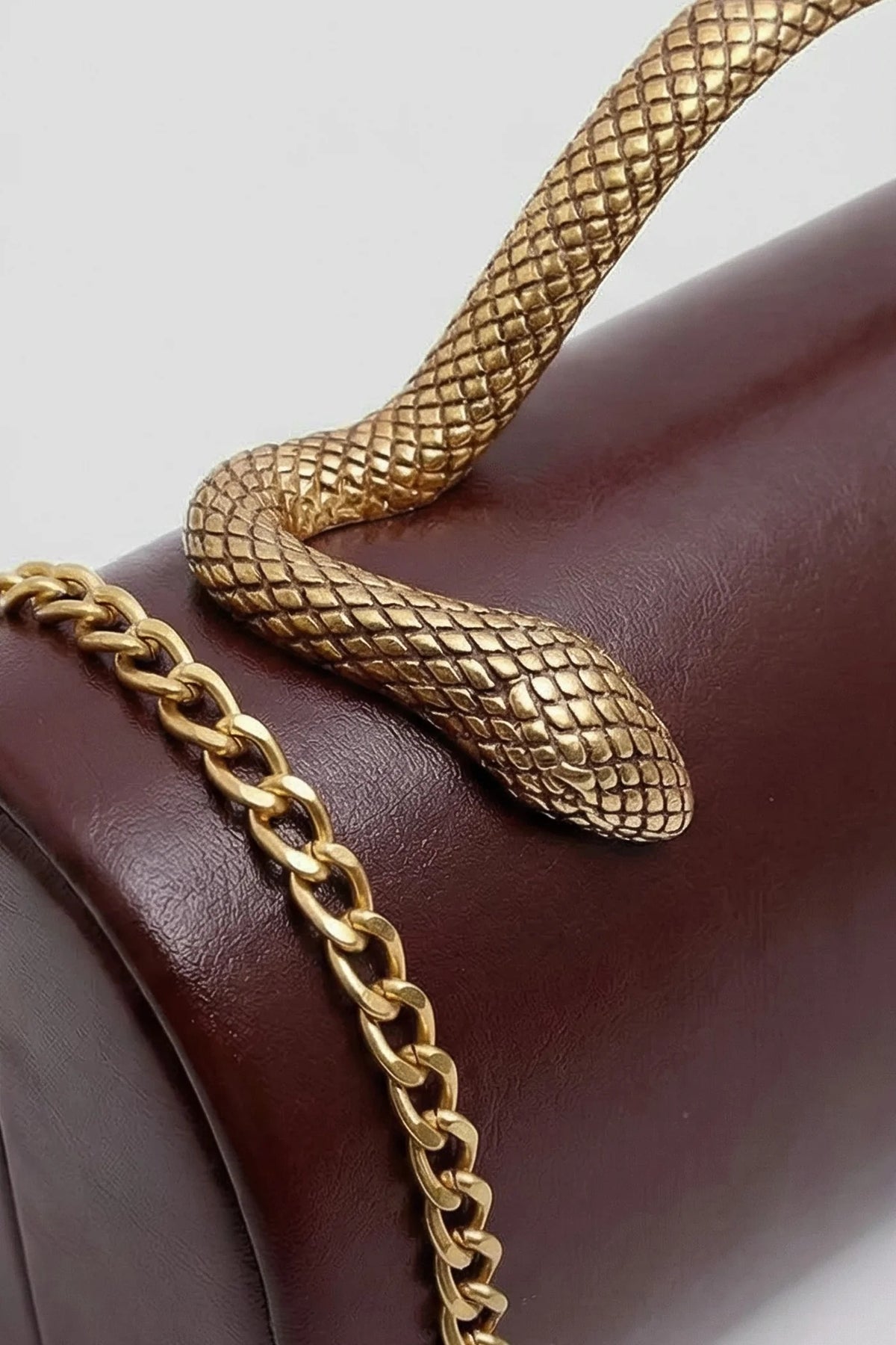 BOLSO DE MANO ESTRUCTURADO CON ASA DE SERPIENTE Y CADENA DORADA - MARRÓN